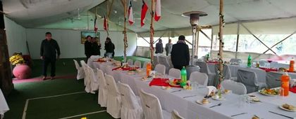 Interior de la carpa de eventos con mesas dispuestas para una celebración.