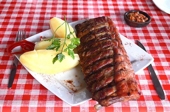 Costillar al horno servido con papas cocidas.