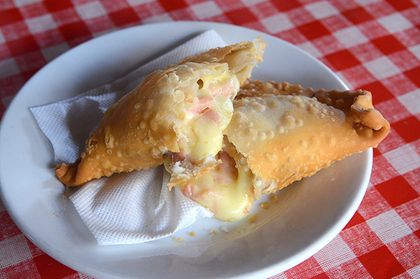 Empanada frita de queso abierta, con el queso fundido a la vista.