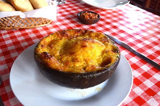 Pastel de choclo gratinado servido en fuente de greda.