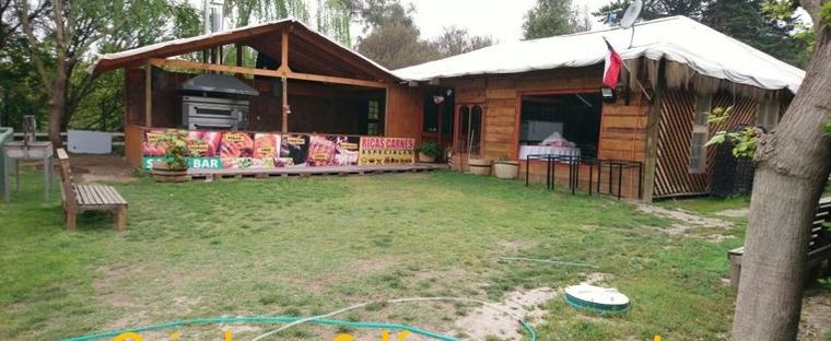 Quincho techado y salón de eventos de Don Benito, rodeados de jardín.