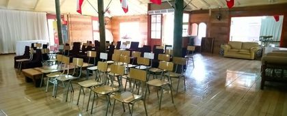 Salón para seminarios con mesas de trabajo y piso de madera.