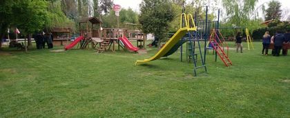Área verde con juegos y cerco de madera.